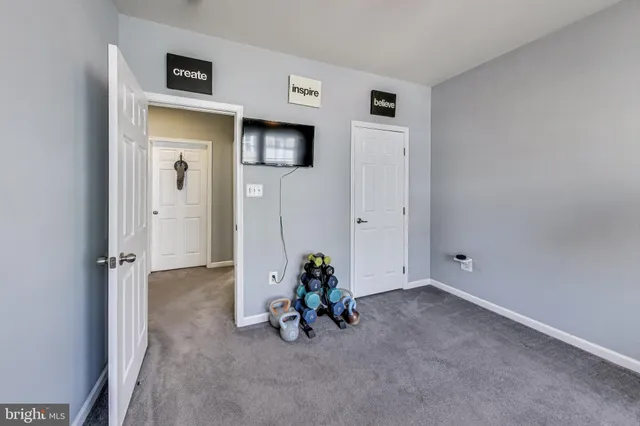 a view of a livingroom with wooden floor and a hallway