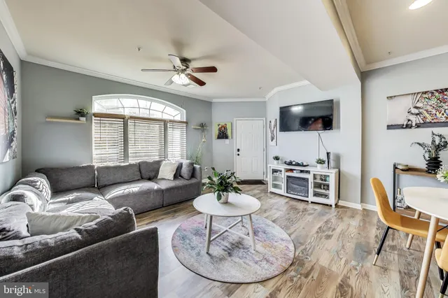 a living room with furniture a window and a flat screen tv
