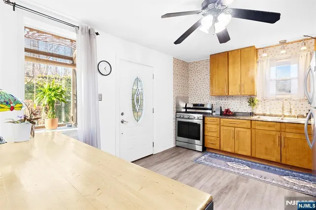 a kitchen with a refrigerator a stove cabinets and a dining table