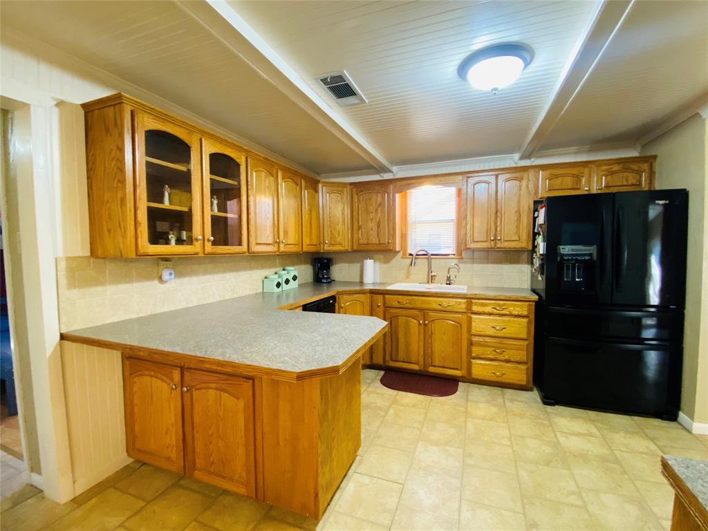 806 North 10th Street Haskell, TX 79521 - Photo 4 of 16 a kitchen with stainless steel appliances granite countertop a refrigerator and cabinets