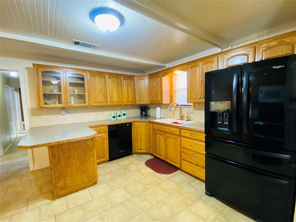 806 North 10th Street Haskell, TX 79521 - Photo 5 of 16 a kitchen with a sink stove and refrigerator