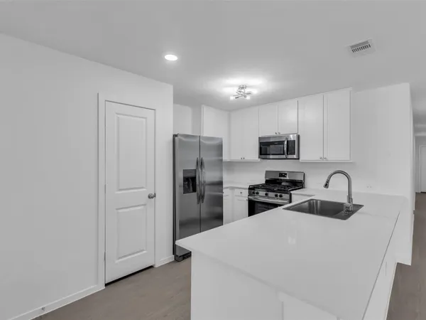 a kitchen with stainless steel appliances a refrigerator sink and microwave