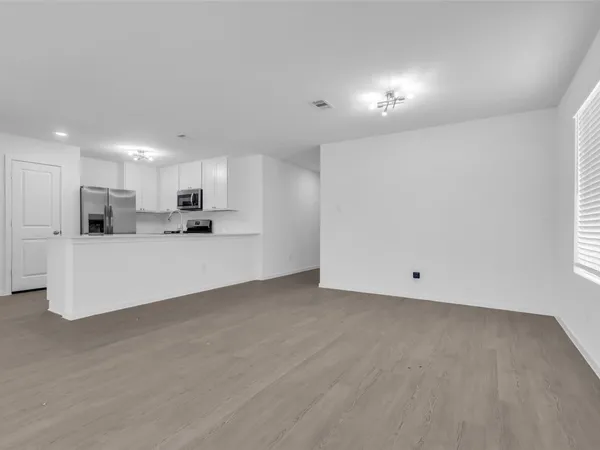 a view of kitchen with refrigerator sink and cabinets