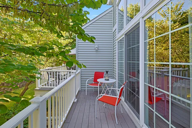 a balcony with wooden floor and some potted plants