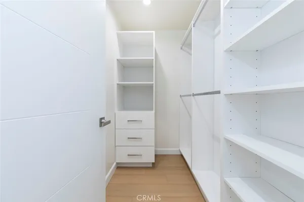 a view of walk in closet with empty racks