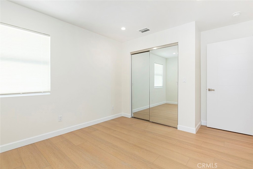 7103 Greeley Street Tujunga, CA 91042 - Photo 19 of 33 an empty room with wooden floor and mirror