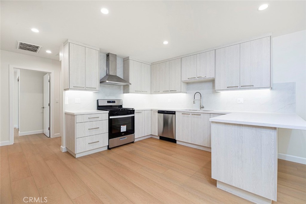 7103 Greeley Street Tujunga, CA 91042 - Photo 8 of 33 a kitchen with stainless steel appliances a white stove top oven cabinets and a refrigerator