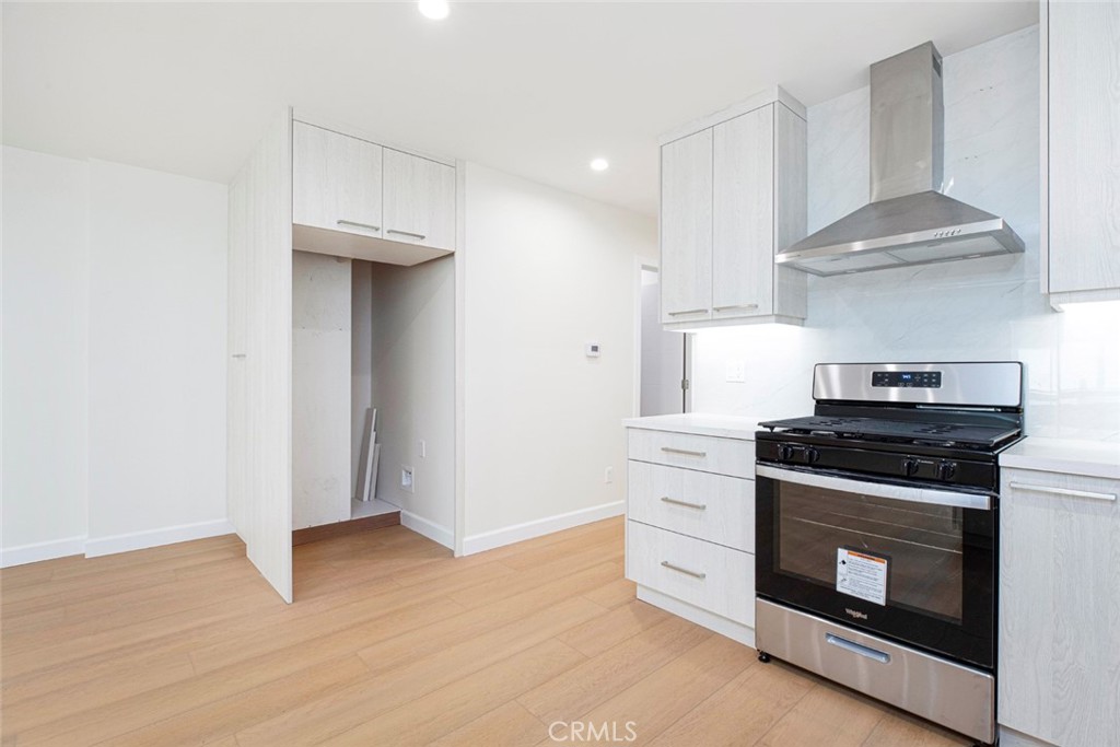 7103 Greeley Street Tujunga, CA 91042 - Photo 9 of 33 a kitchen with a stove and a wooden floor