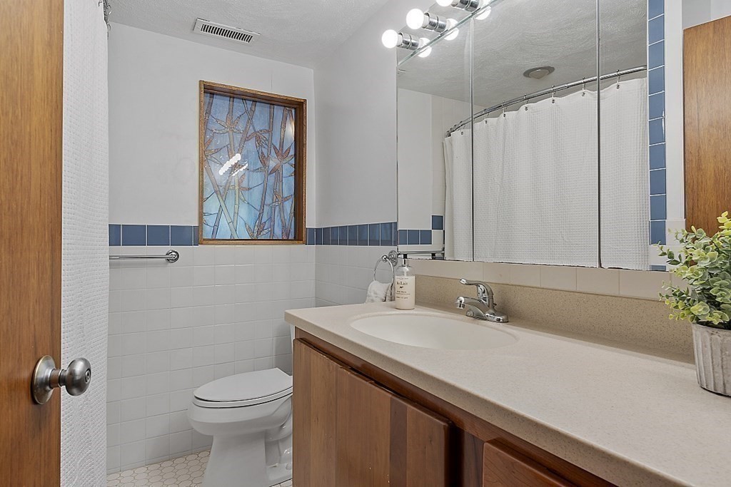 153 Middle Road Boxborough, MA 01719 - Photo 32 of 36 a bathroom with a sink a toilet and mirror