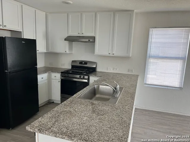 a kitchen with a refrigerator stove and cabinets