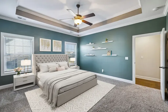 a bedroom with a large bed chandelier and a window