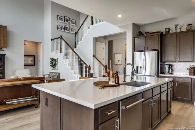 a kitchen with stainless steel appliances a sink stove and refrigerator