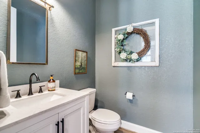 a bathroom with a toilet a sink and mirror