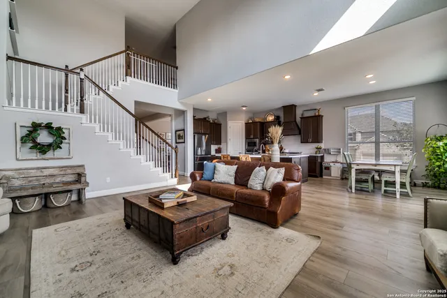 a living room with furniture and a dining table with wooden floor