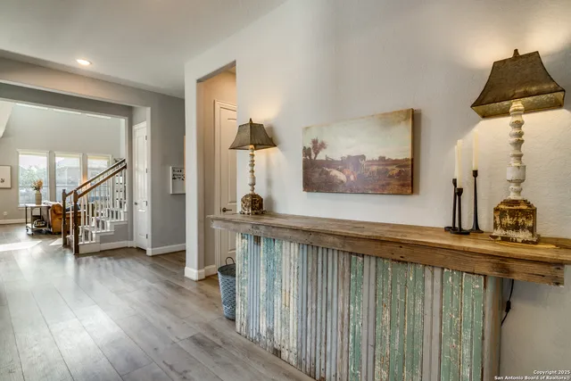 a view of a hallway to a livingroom with wooden floor and furniture