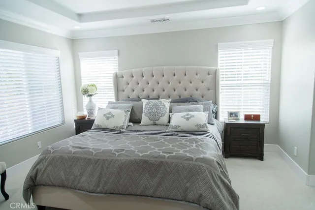 a large bed sitting in a bedroom next to a window with lamp