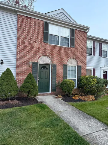 a front view of a house with a yard and potted plants