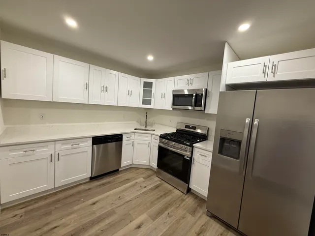 a kitchen with cabinets stainless steel appliances and a counter space