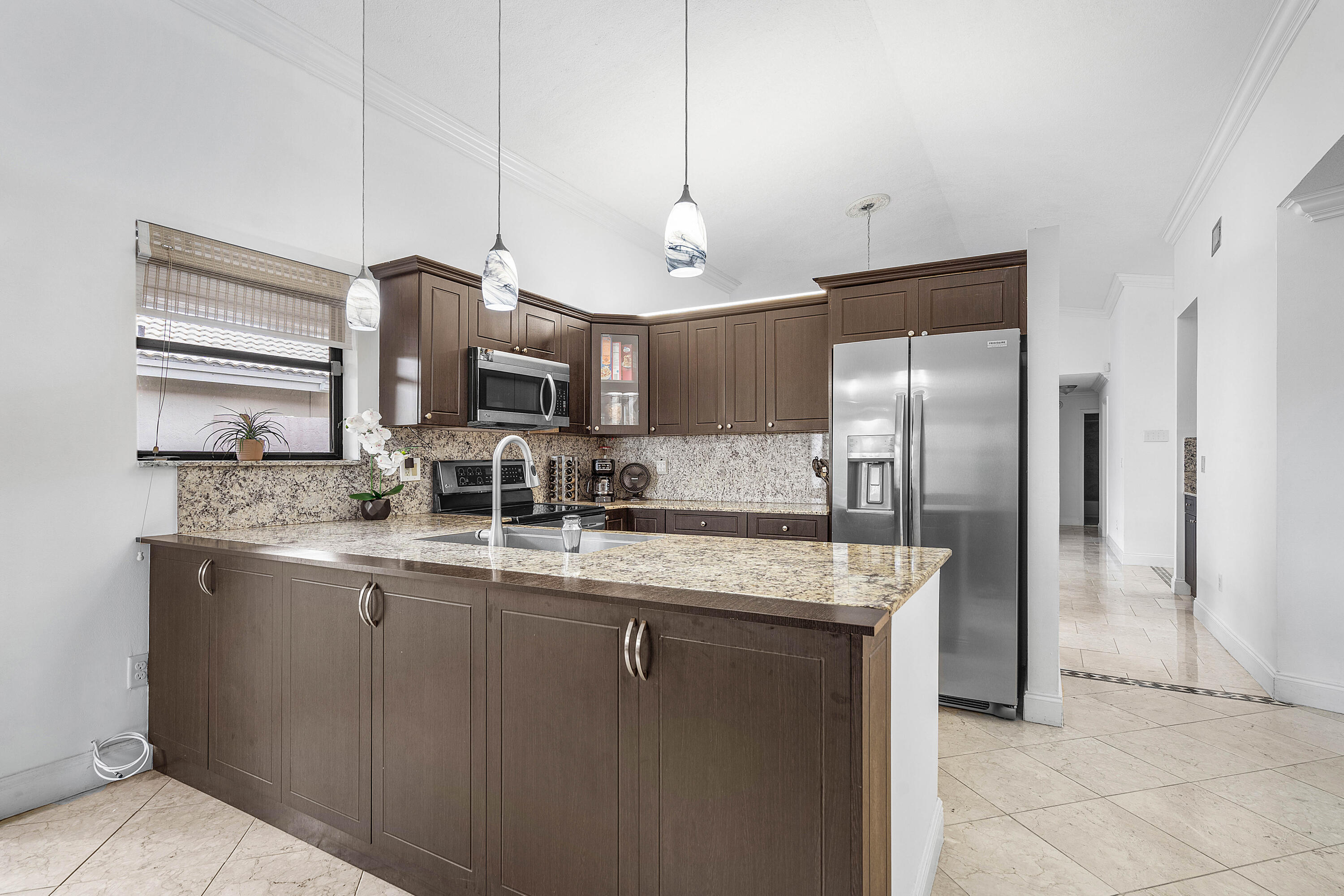 6100 Manchester Lane Davie, FL 33331 - Photo 12 of 30 a kitchen with stainless steel appliances granite countertop a sink a refrigerator and a granite counter tops