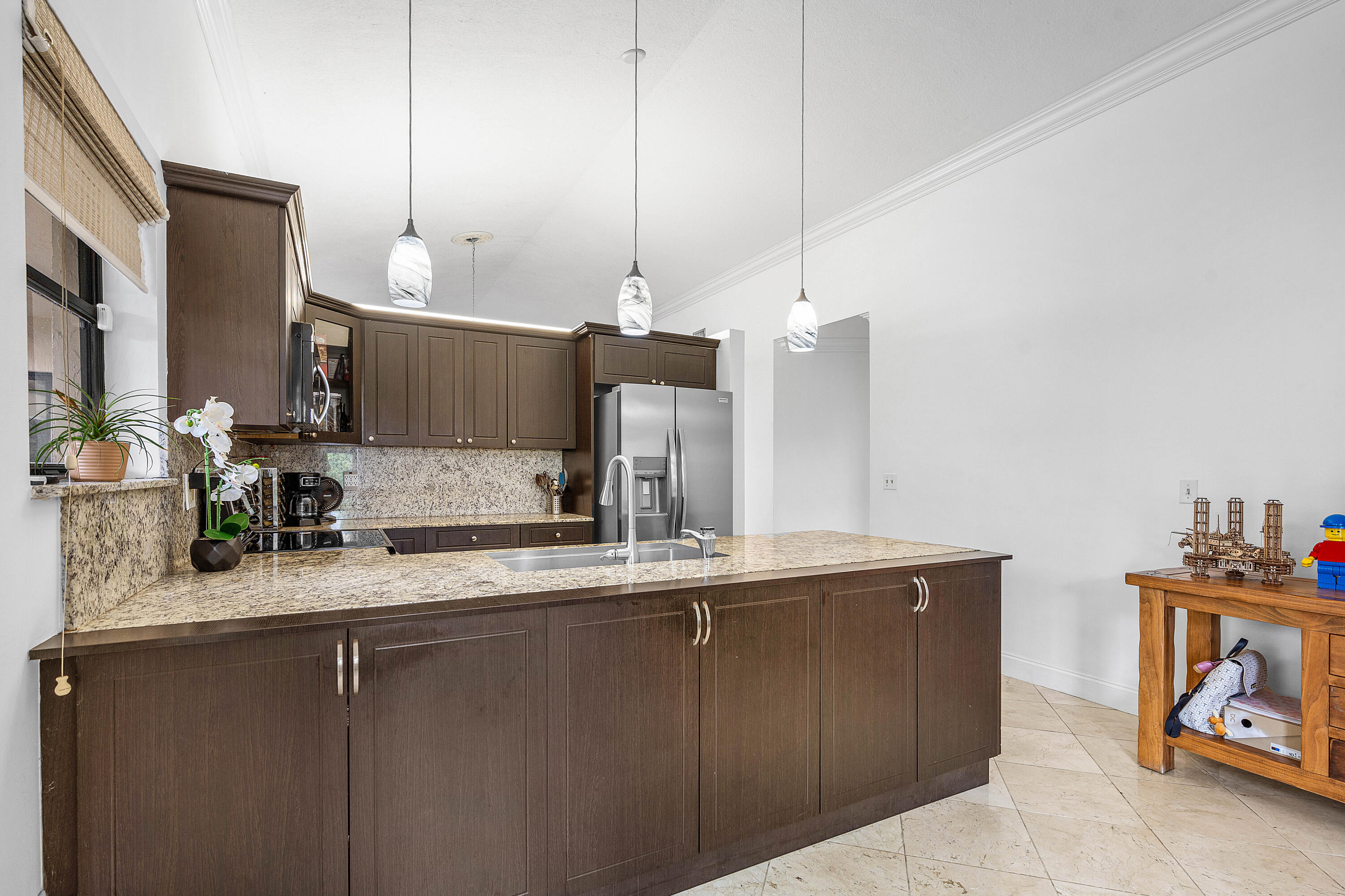 6100 Manchester Lane Davie, FL 33331 - Photo 13 of 30 a kitchen with kitchen island granite countertop a sink a counter space and cabinets