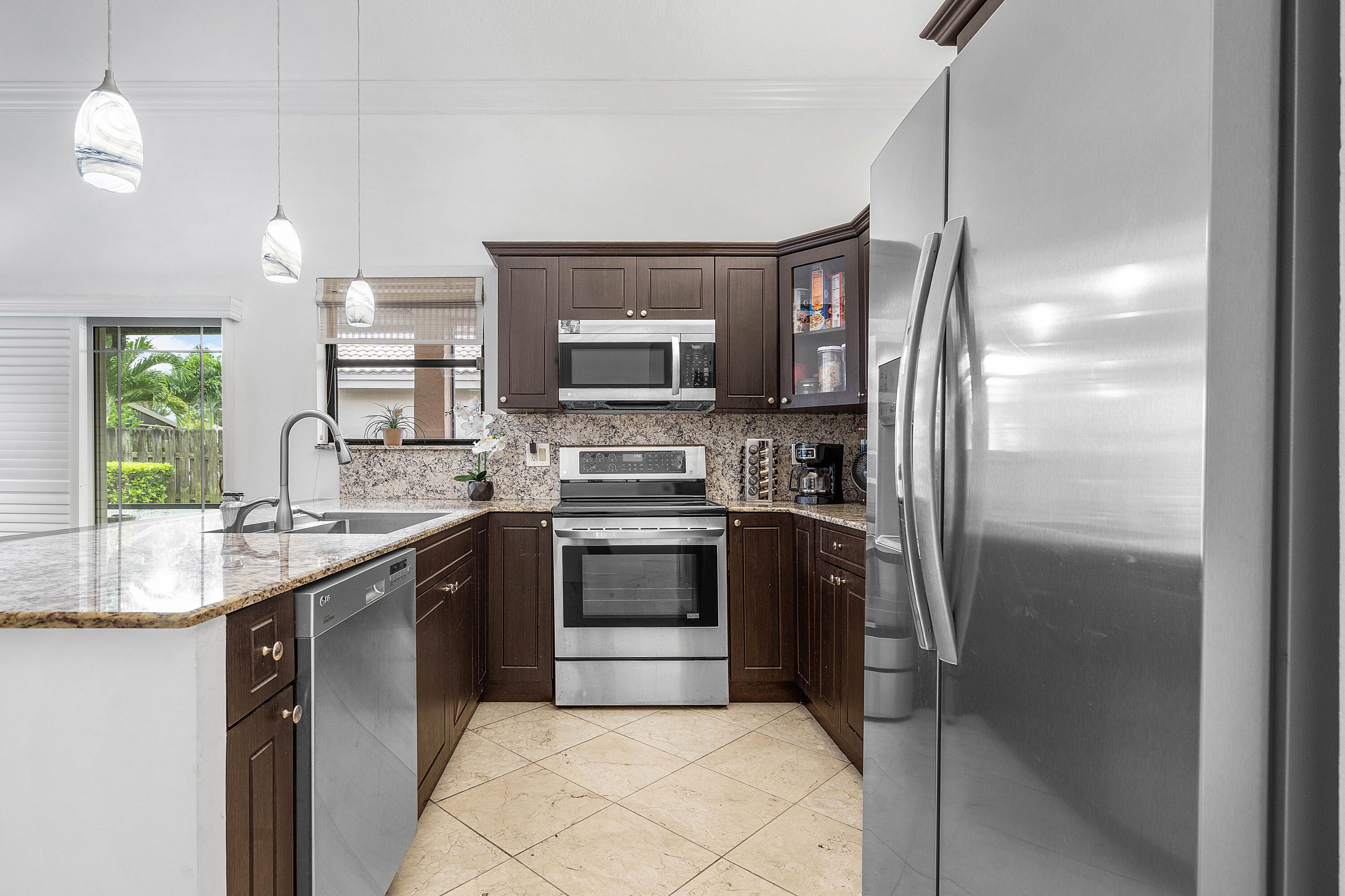 6100 Manchester Lane Davie, FL 33331 - Photo 14 of 30 a kitchen with stainless steel appliances granite countertop a refrigerator a stove a sink and a microwave