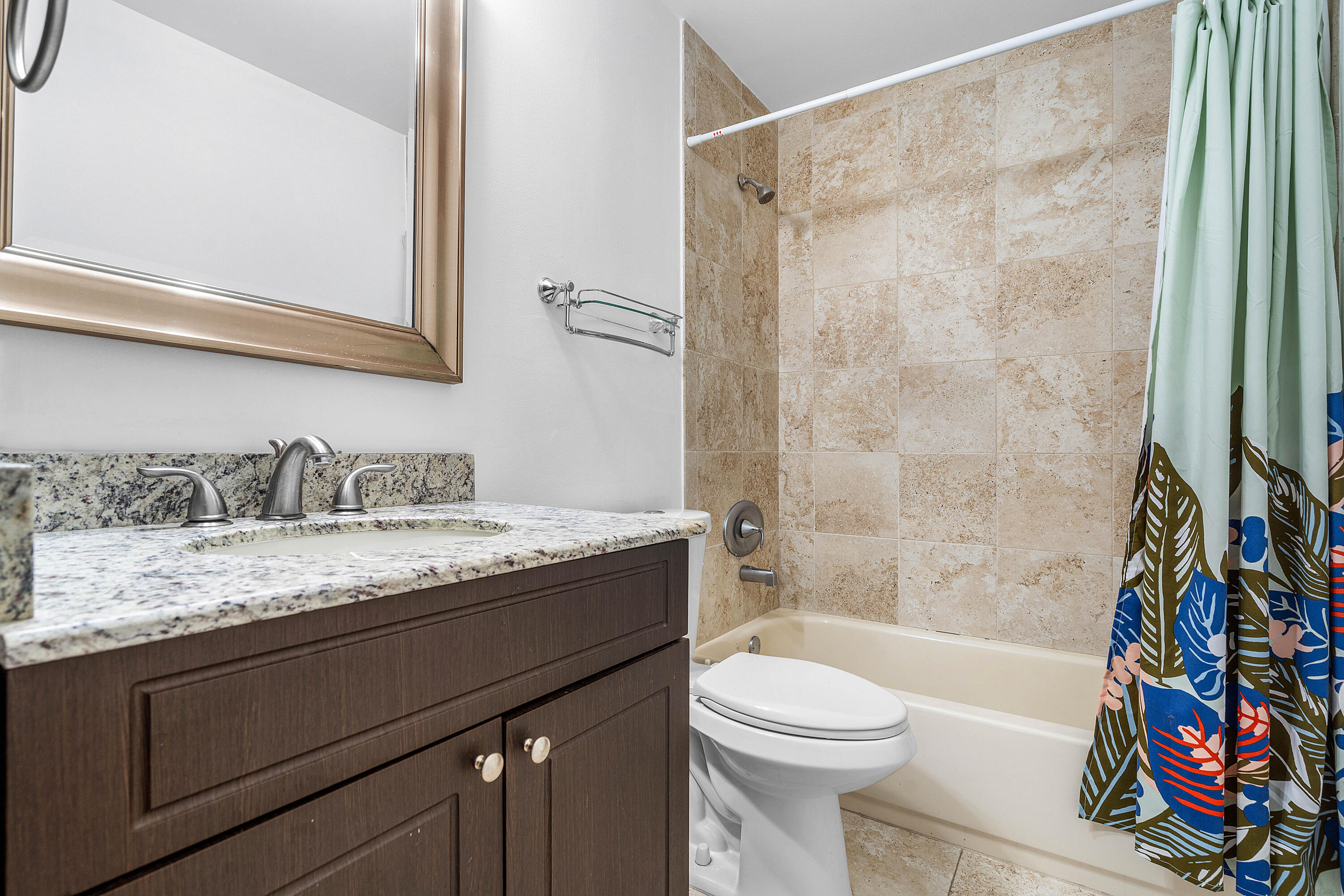 6100 Manchester Lane Davie, FL 33331 - Photo 23 of 30 a bathroom with a granite countertop sink a toilet a mirror a bathtub and shower