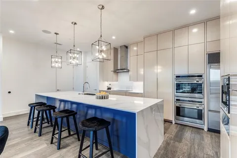 a kitchen with stainless steel appliances a dining table chairs and wooden floor