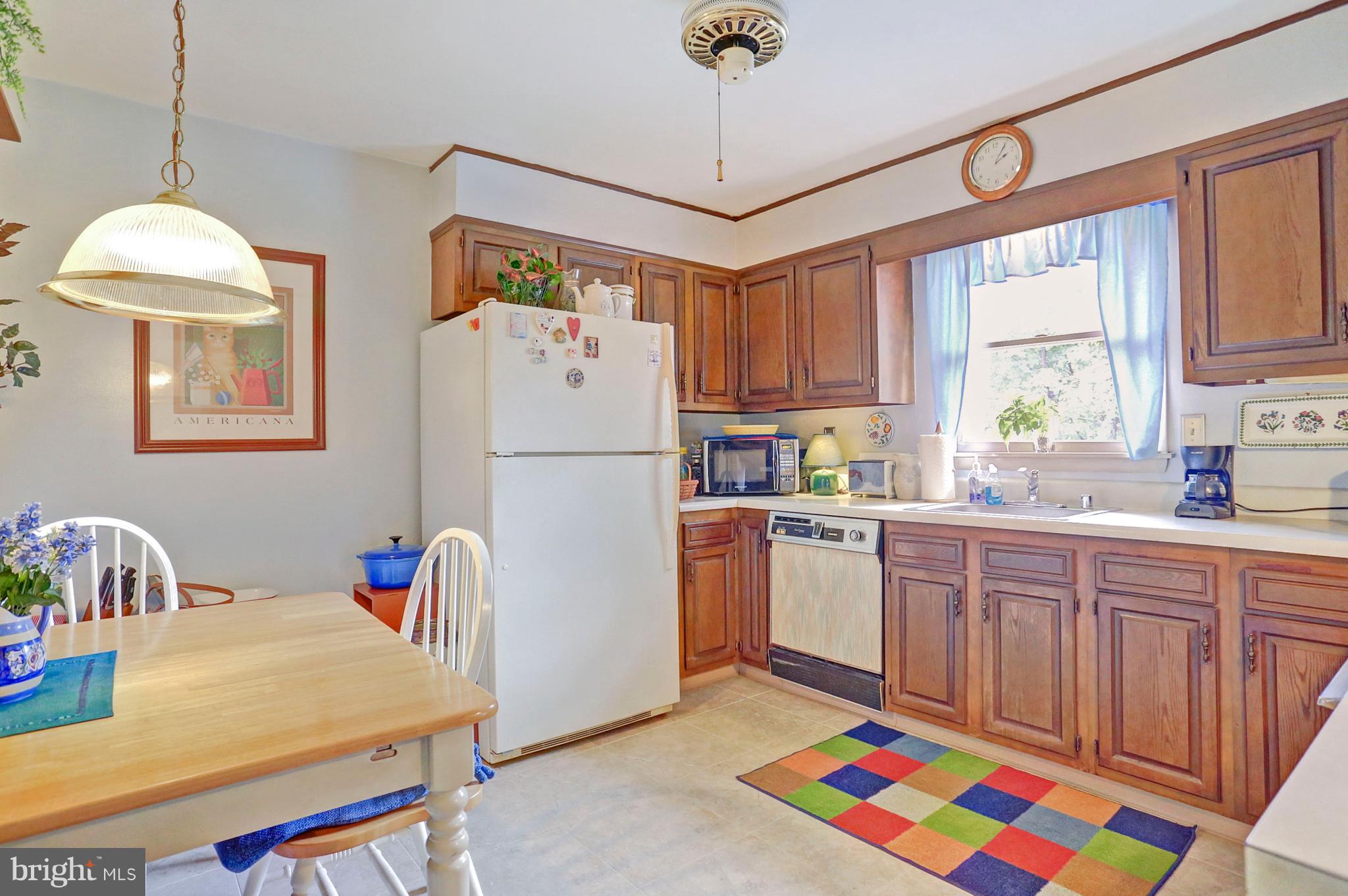 3644 Water Tank Road Manchester, MD 21102 - Photo 6 of 37 a kitchen with a refrigerator a sink dishwasher a dining table and chairs with wooden floor