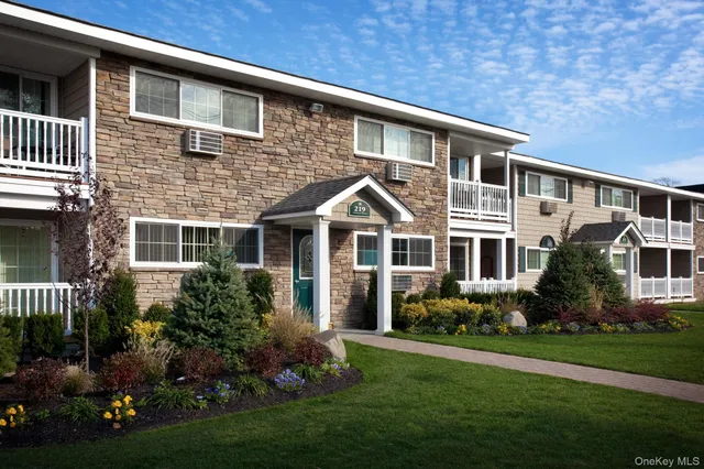 a front view of a house with a yard and potted plants
