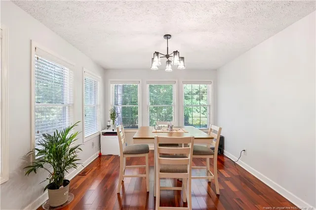a view of a dining room with furniture a chandelier and wooden floor