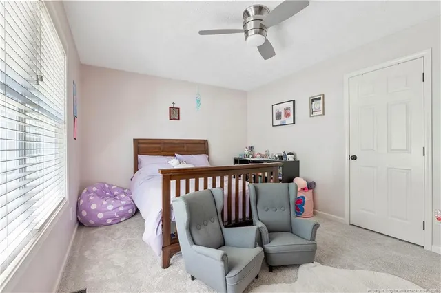 a bed sitting in a spacious bedroom next to a window