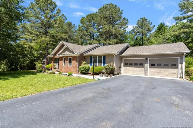 a wooden bench sitting in a park with large trees