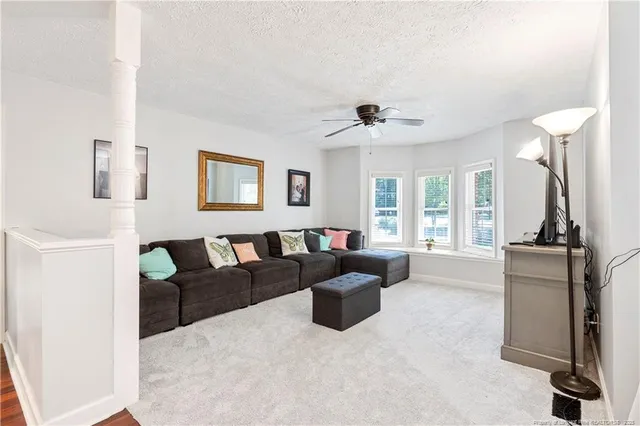 a living room with furniture and a view of kitchen