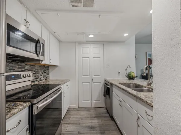 a kitchen counter with a sink and a chandelier