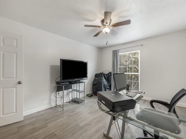 a work room with furniture a wooden floor and a window
