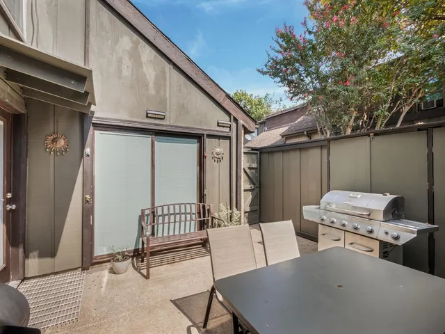 a backyard of a house with barbeque oven table and chairs