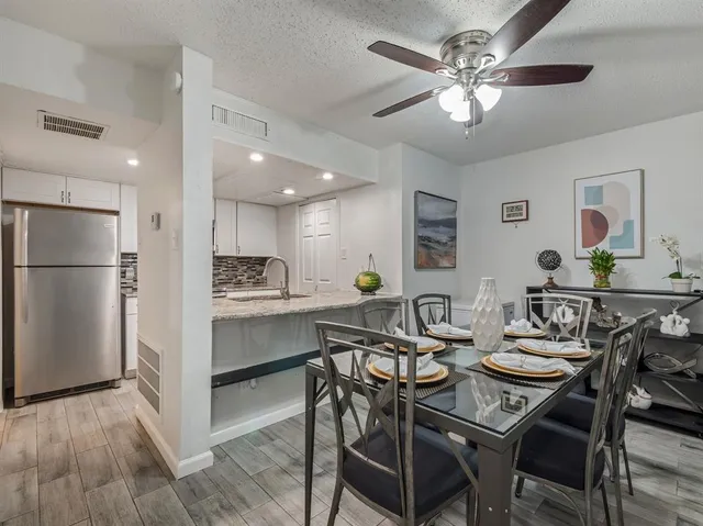 a view of a dining room with furniture and a chandelier fan