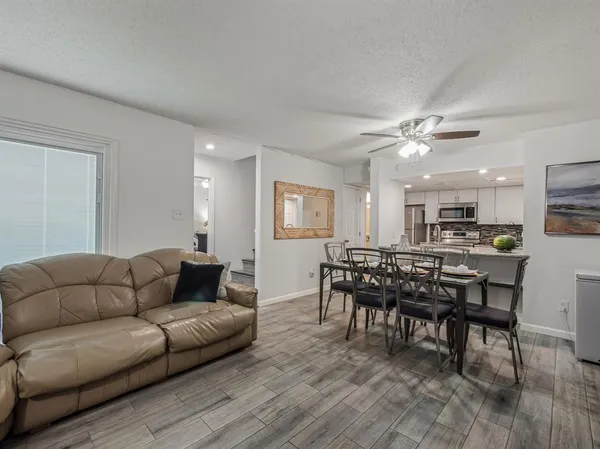 a living room with furniture kitchen and a dining table