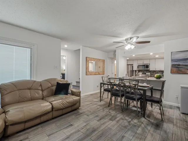 a living room with furniture kitchen and a dining table