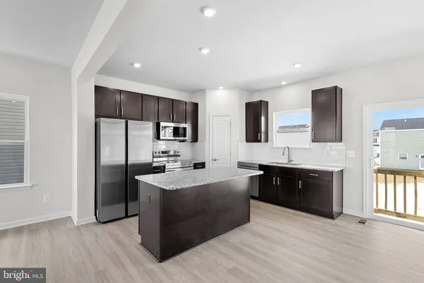a large kitchen with stainless steel appliances granite countertop a refrigerator and a sink
