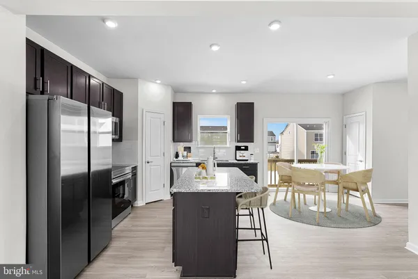 a large kitchen with kitchen island a large counter top and stainless steel appliances