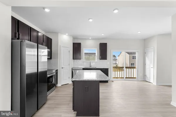 an empty room with wooden floor cabinet and windows