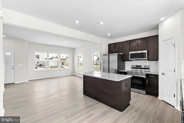 a large kitchen with stainless steel appliances and wooden cabinets