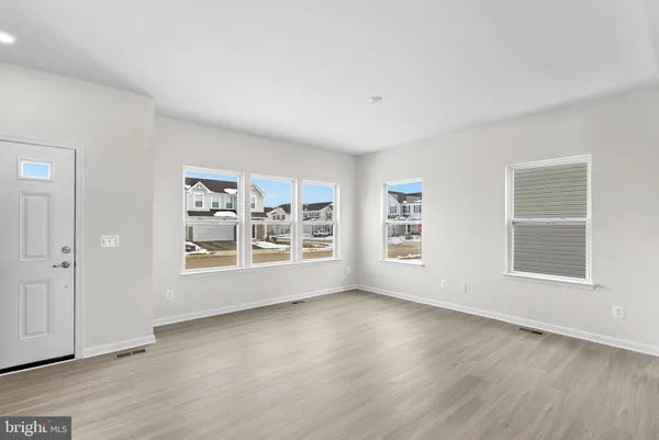an empty room with wooden floor and window