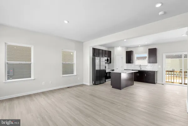 a large white kitchen with a large window and kitchen island
