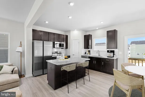 a large kitchen with stainless steel appliances a sink a stove a refrigerator and cabinets