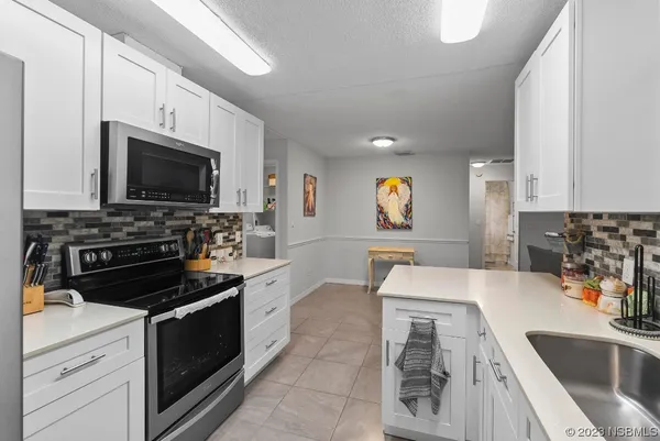a kitchen with a sink stove and white cabinets
