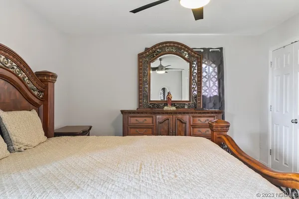 a bedroom with a bed a chandelier and dresser