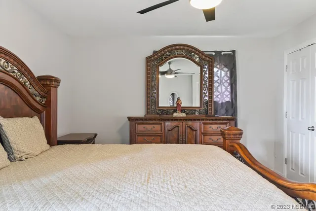 a bedroom with a bed a chandelier and dresser