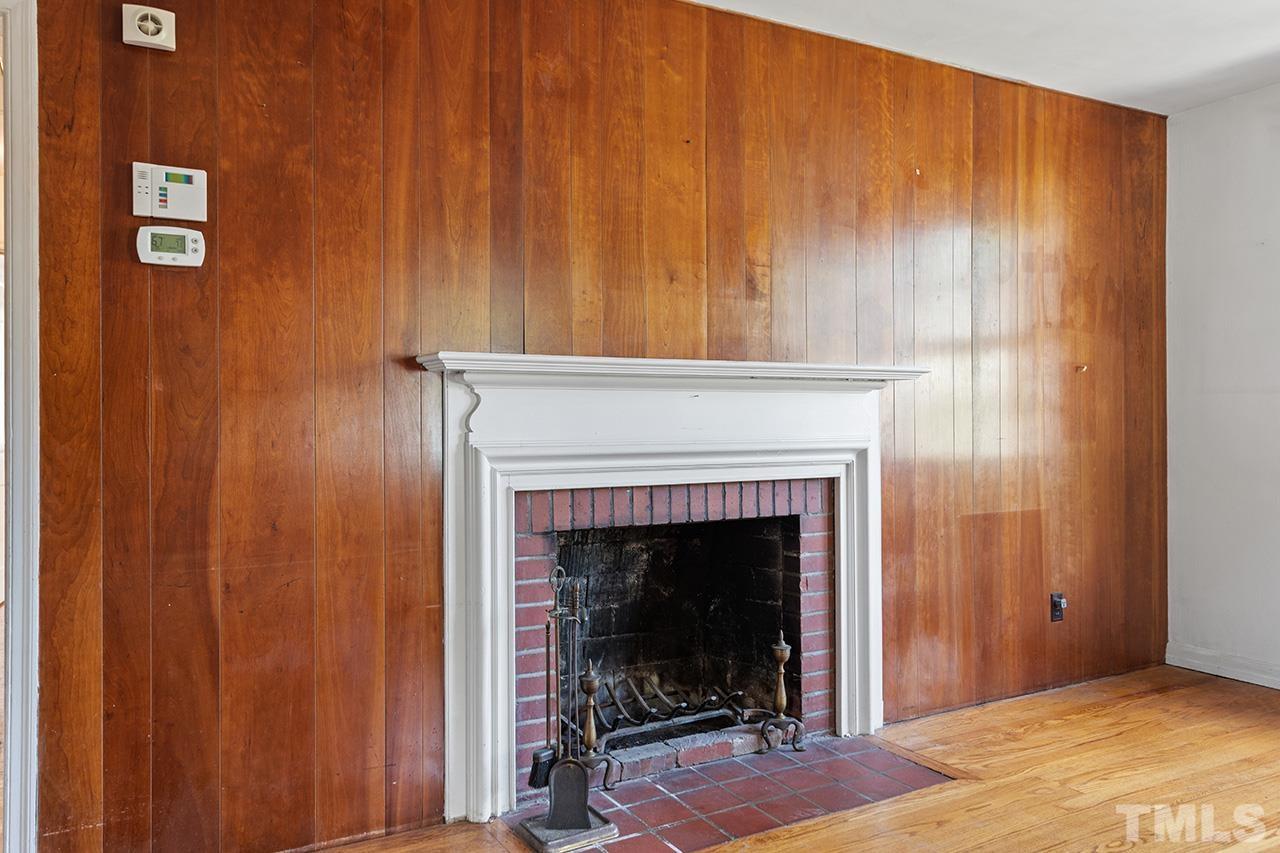 1208 Clifton Street Raleigh, NC 27604 - Photo 12 of 33 a view of an empty room with wooden floor and a fireplace